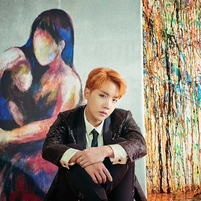 j-hope posing in front a painting resembling a mother and her child