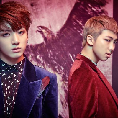 Jungkook and RM posing in front of the painting with the bird during the photo shoot
